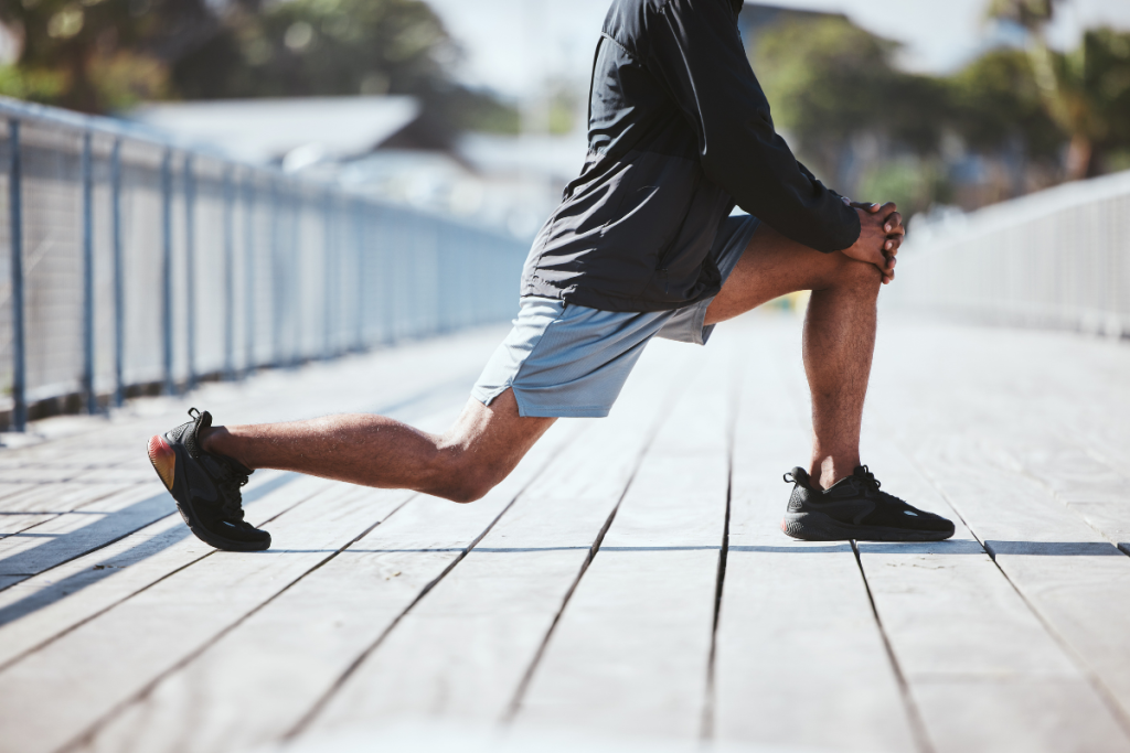 A man stretching outside to prevent an injury.