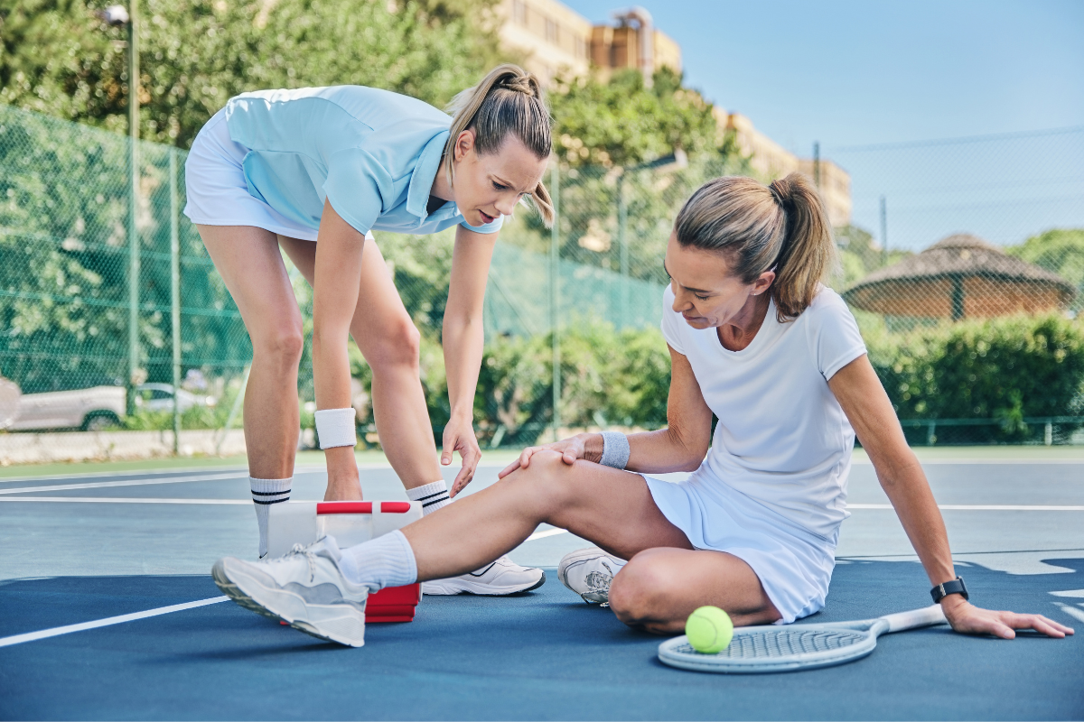 A tennis medic helping woman with knee injury in Manhattan, NY.